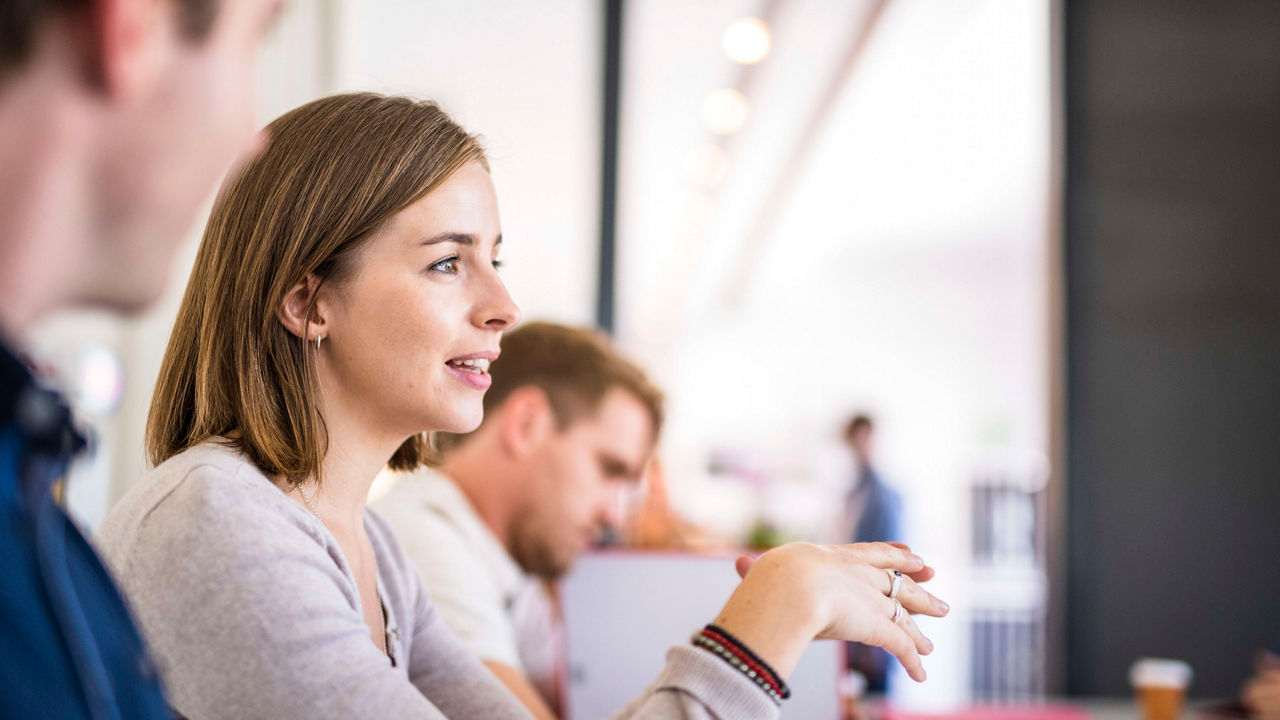 A group of people sitting at a table in an office.
