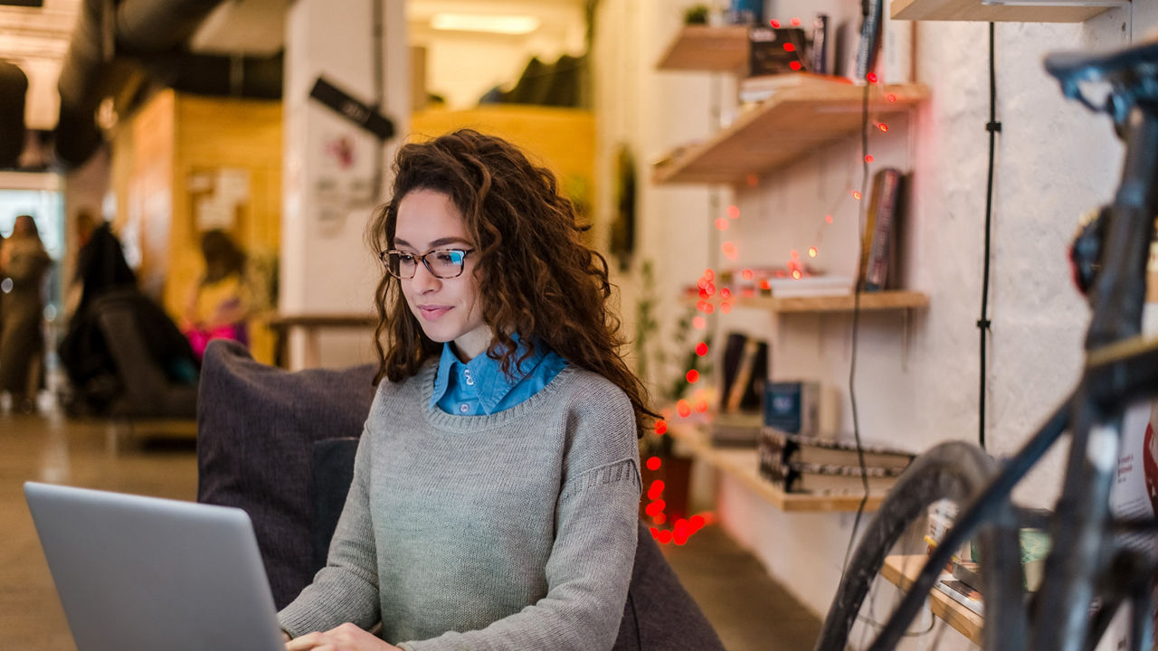 A woman working on a laptop in an office.