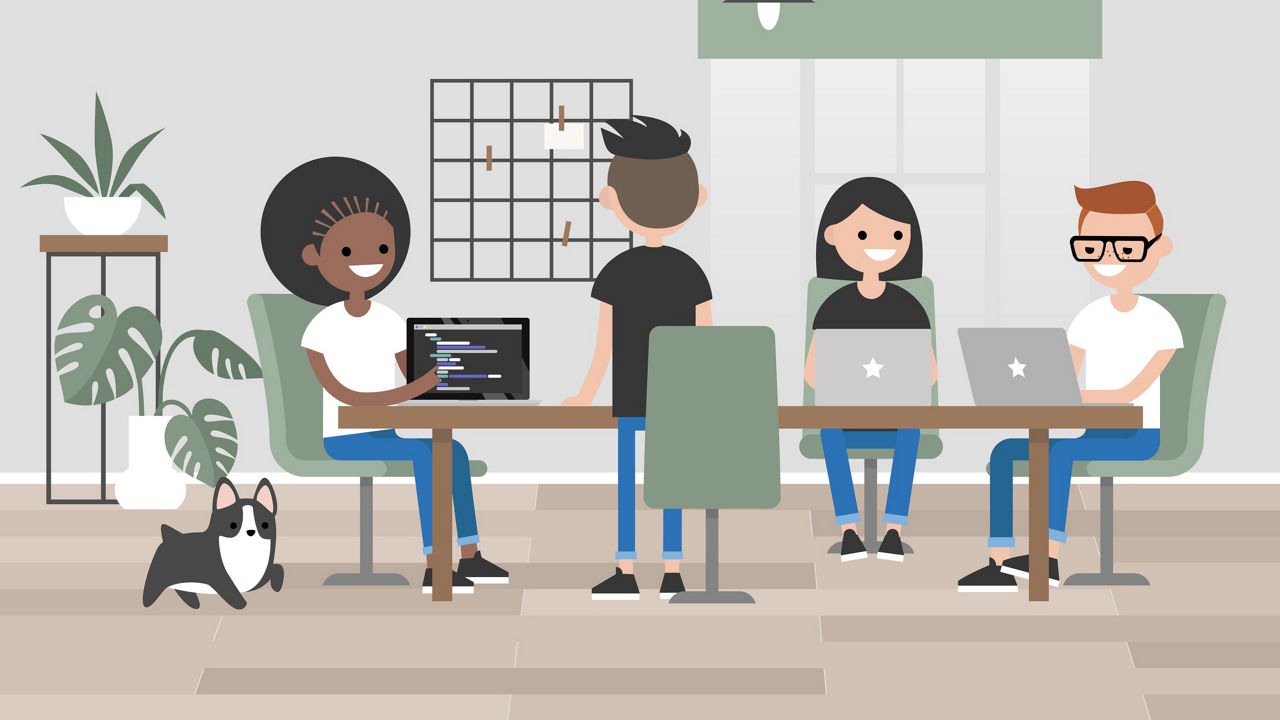 A group of people sitting around a table with laptops.