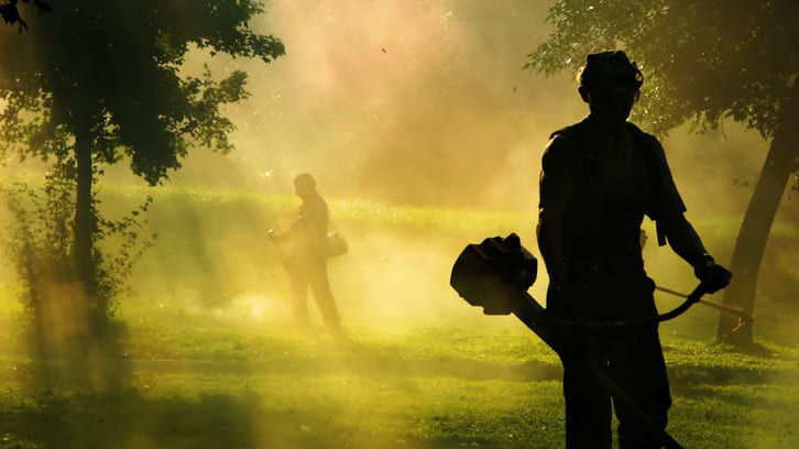 A silhouette of a man with a lawn mower.
