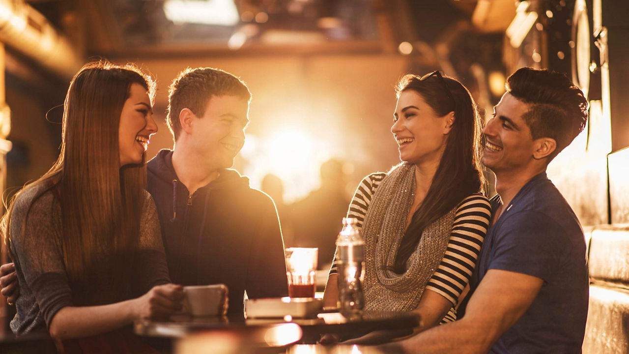 A group of friends sitting at a table in a bar.