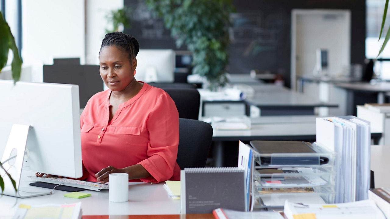 A woman working at a computer in an office.