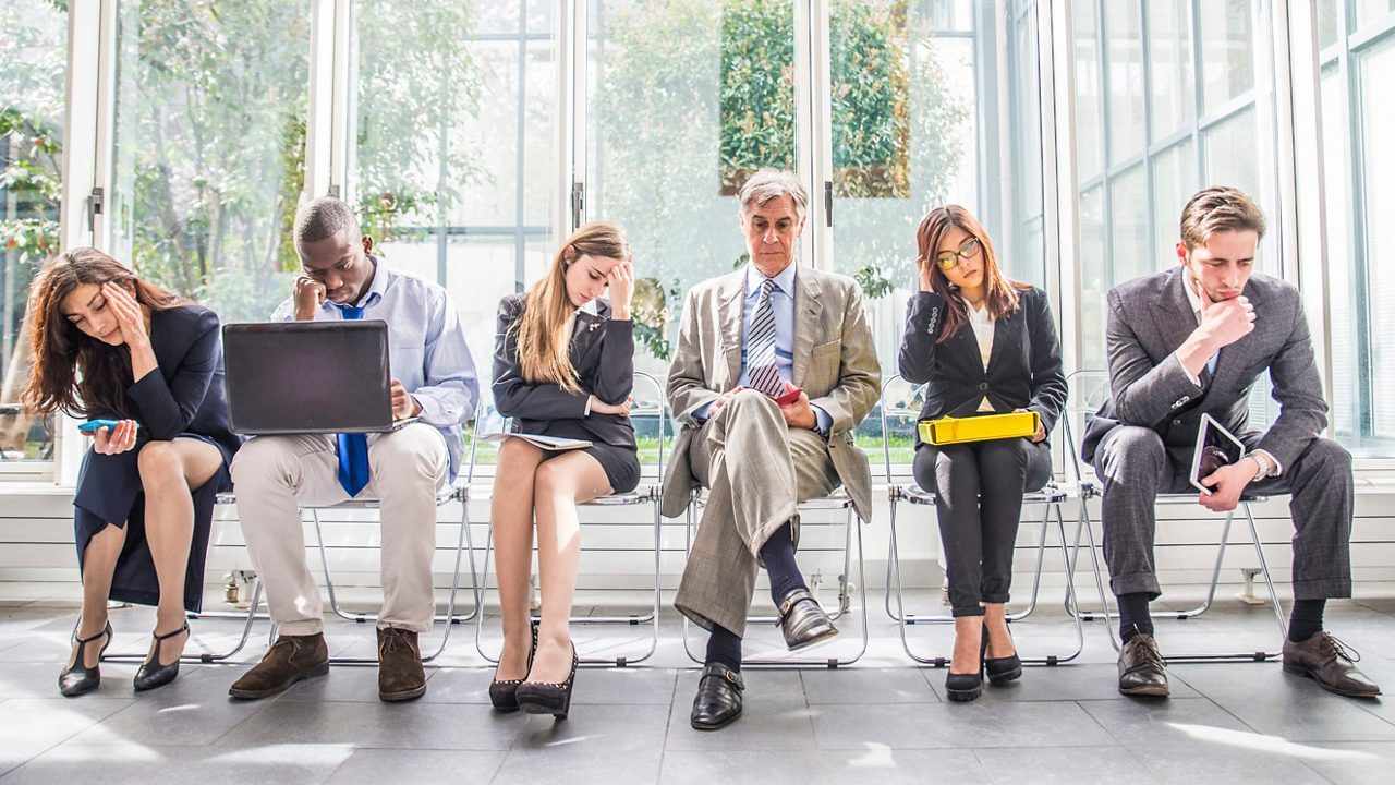 A group of business people sitting in a line.