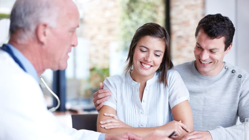 Couple talking with doctor