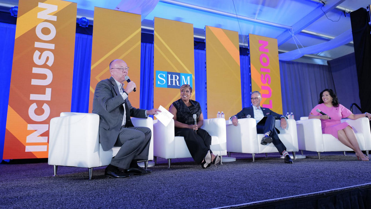 A group of people sitting on chairs at an event.