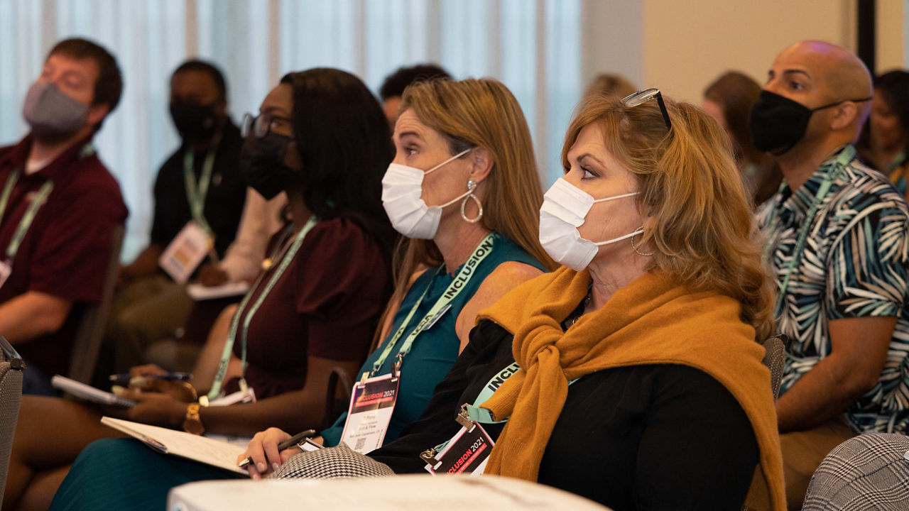 A group of people wearing face masks at a conference.