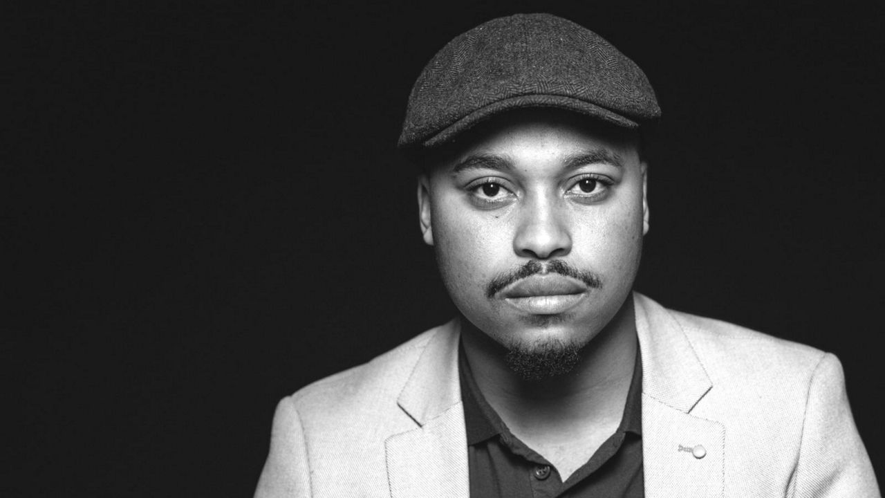 A black and white photo of a man in a hat.