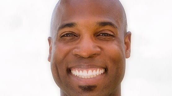 A man in a suit and tie smiling.