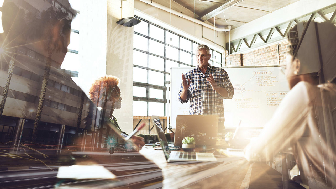 A group of people sitting around a table in a conference room.