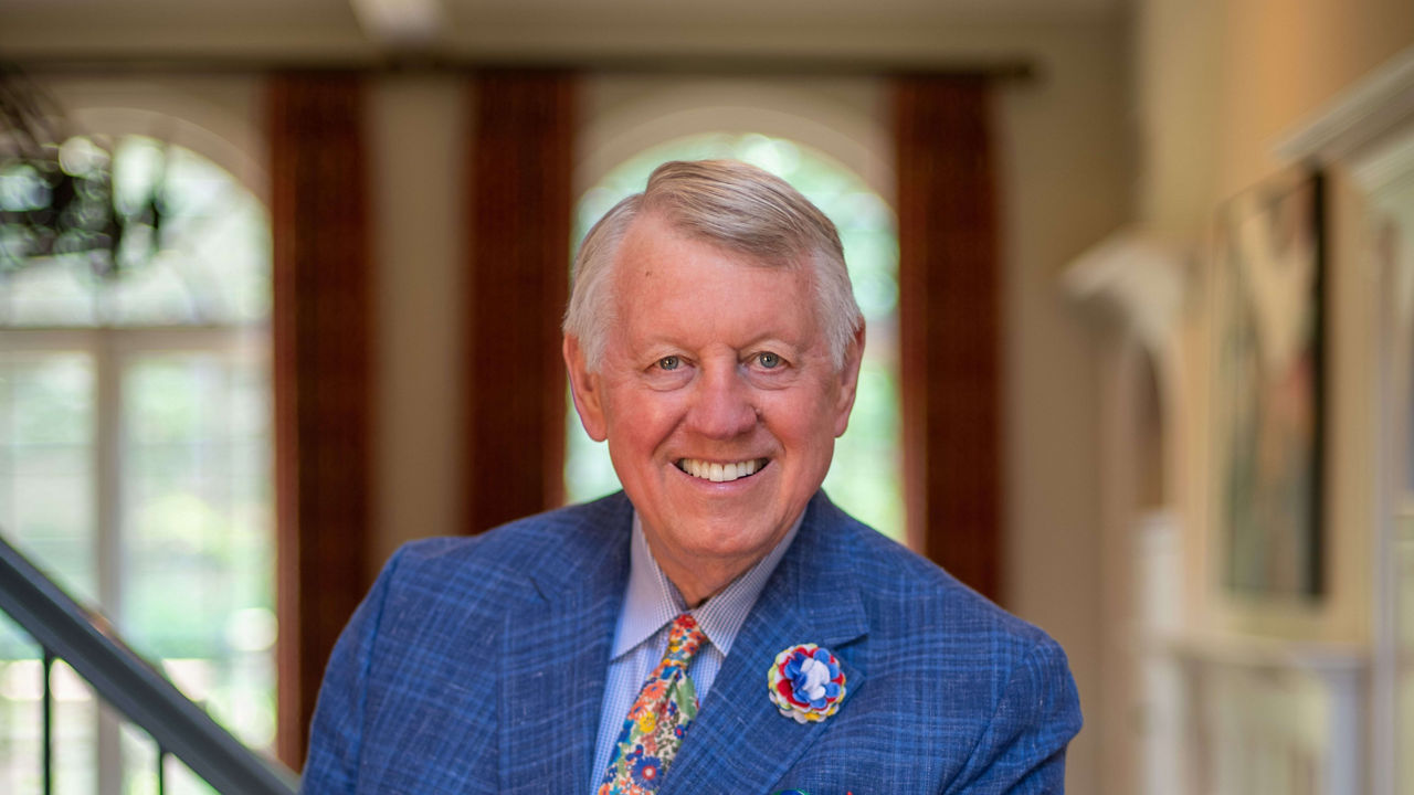 A man in a blue suit standing on a staircase.
