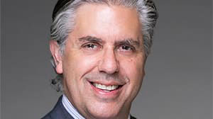 A man in a suit and tie is smiling.