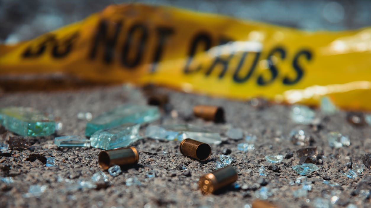 Gunshots and bullets on the ground with a do not cross sign.