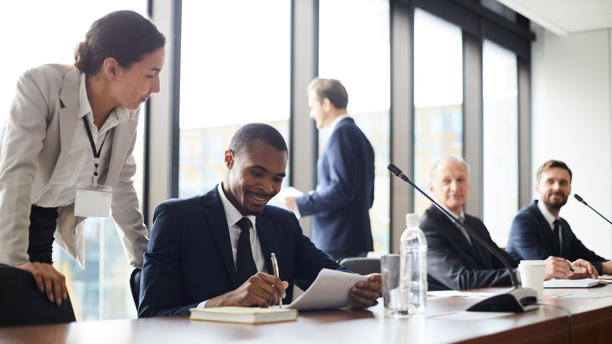 A group of business people sitting at a conference table.