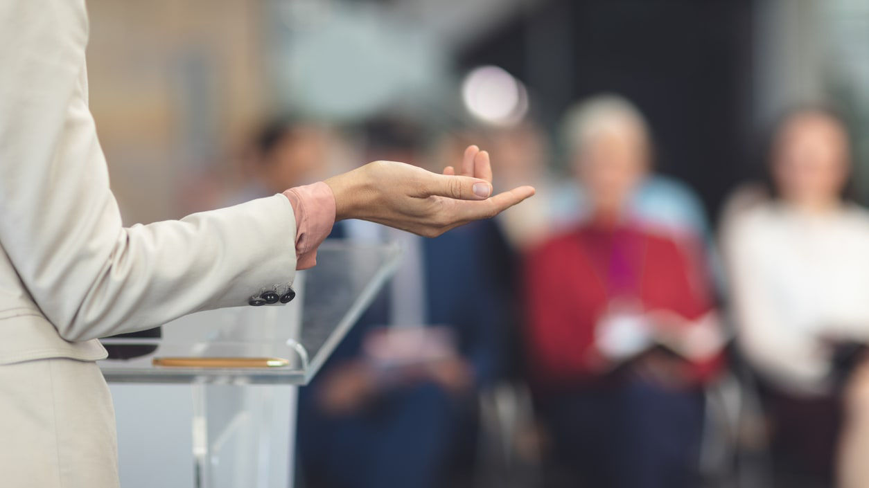 A woman is giving a presentation to a group of people.