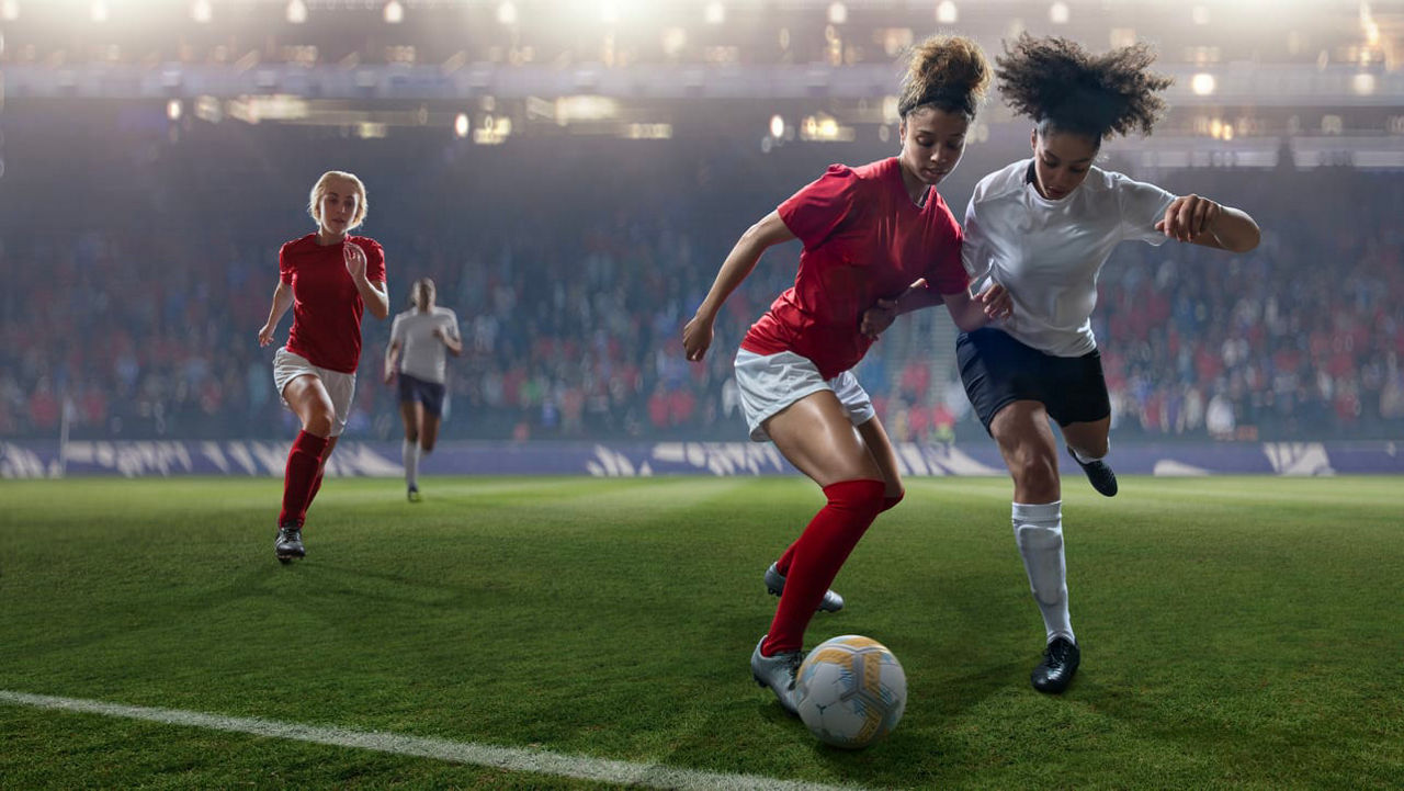 A group of women are playing soccer on a field.
