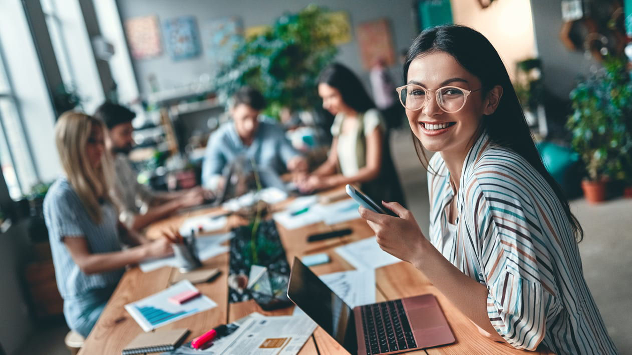 A group of people sitting around a table in an office.