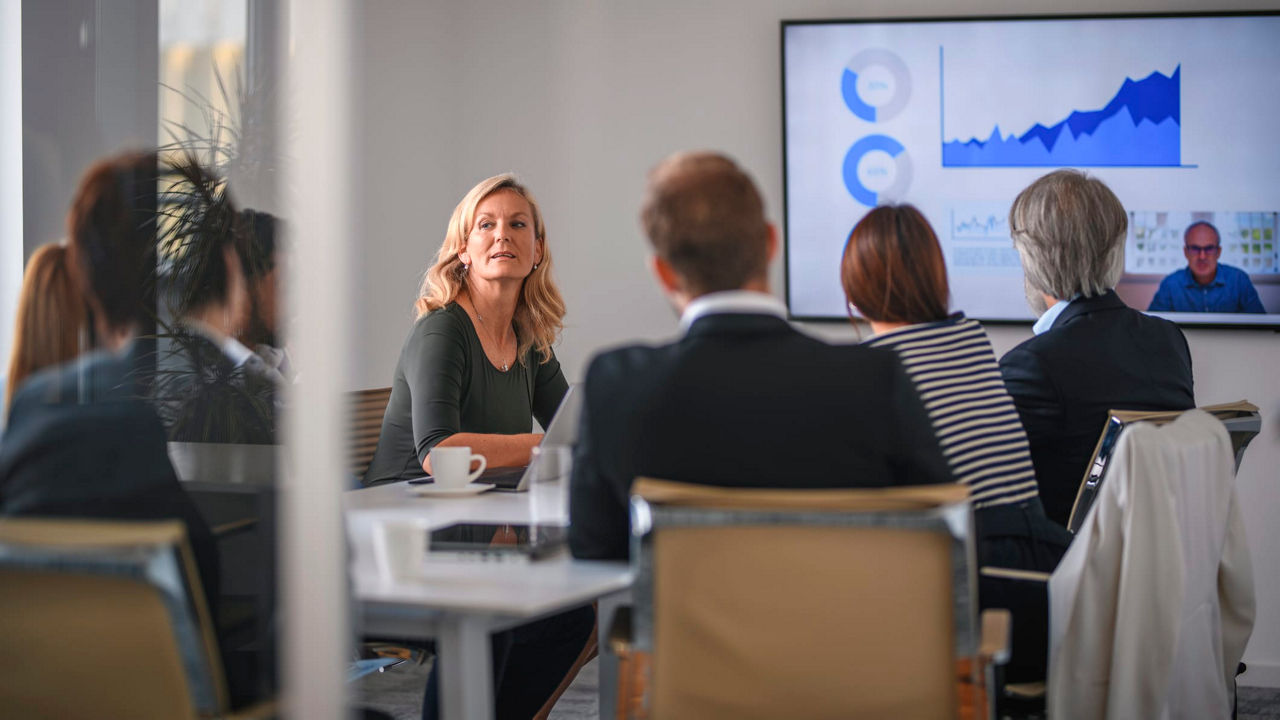 A group of people sitting around a table in a conference room.