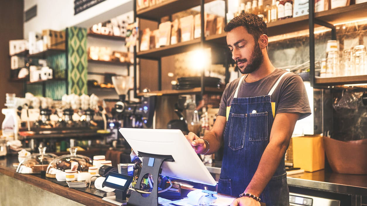 A barista working at a counter in a coffee shop.