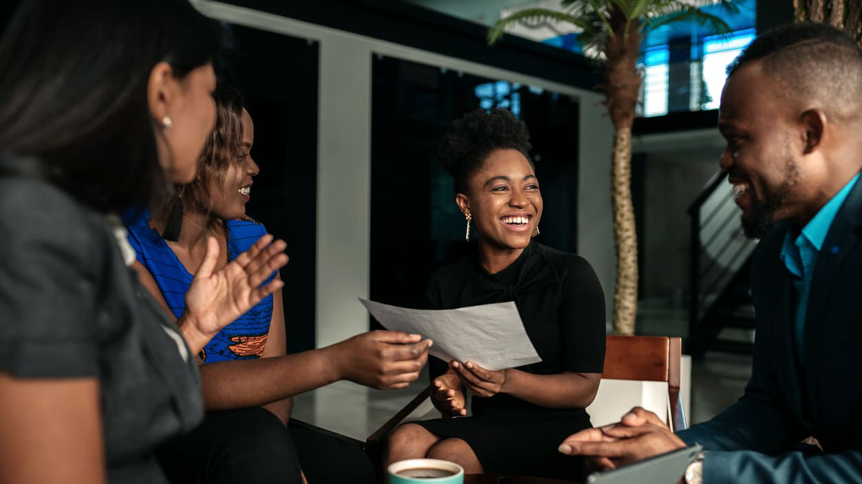 A group of business people sitting around a table and talking.
