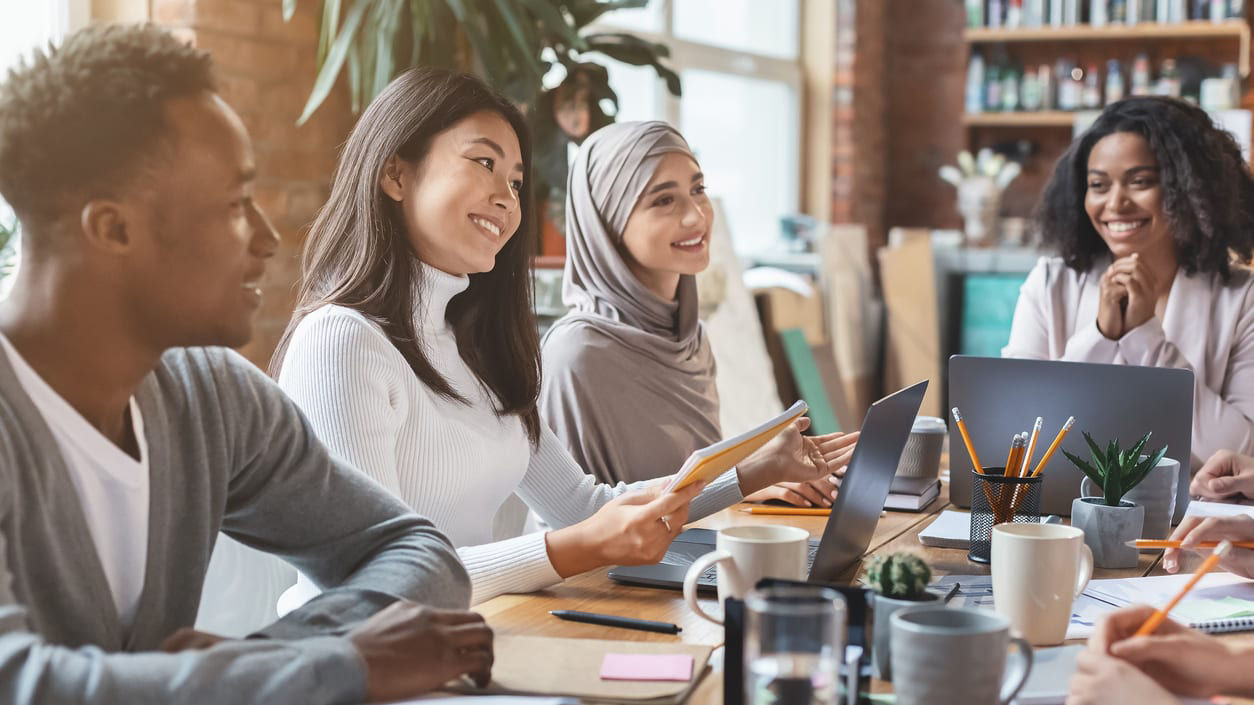 A group of people sitting around a table in an office.