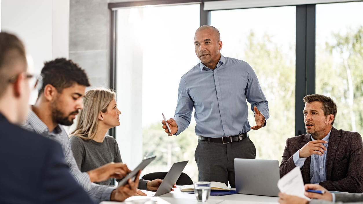 Businessman giving a presentation to a group of people in a conference room.