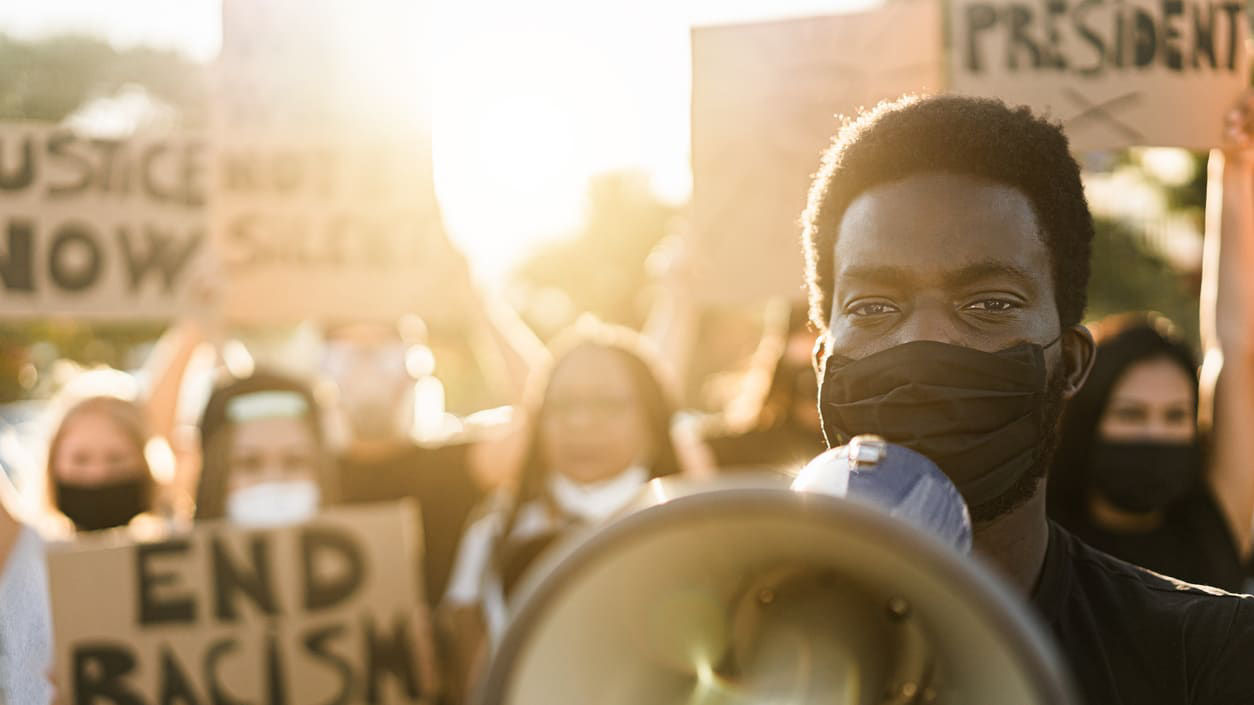 A man holding a megaphone while holding signs.