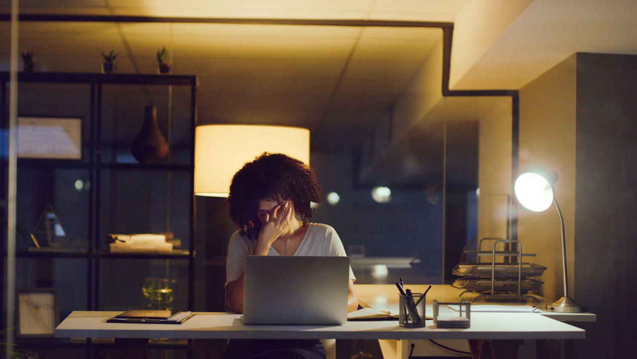 A woman working on her laptop at night.
