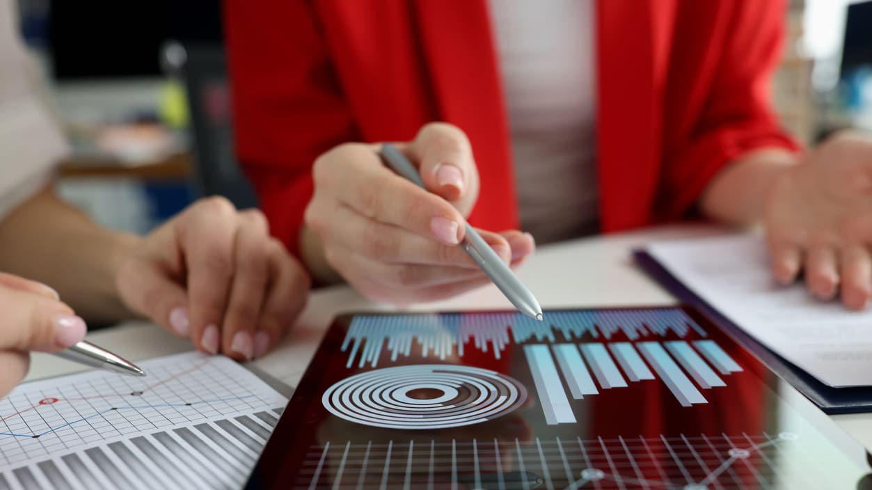 A group of people looking at graphs on a tablet.