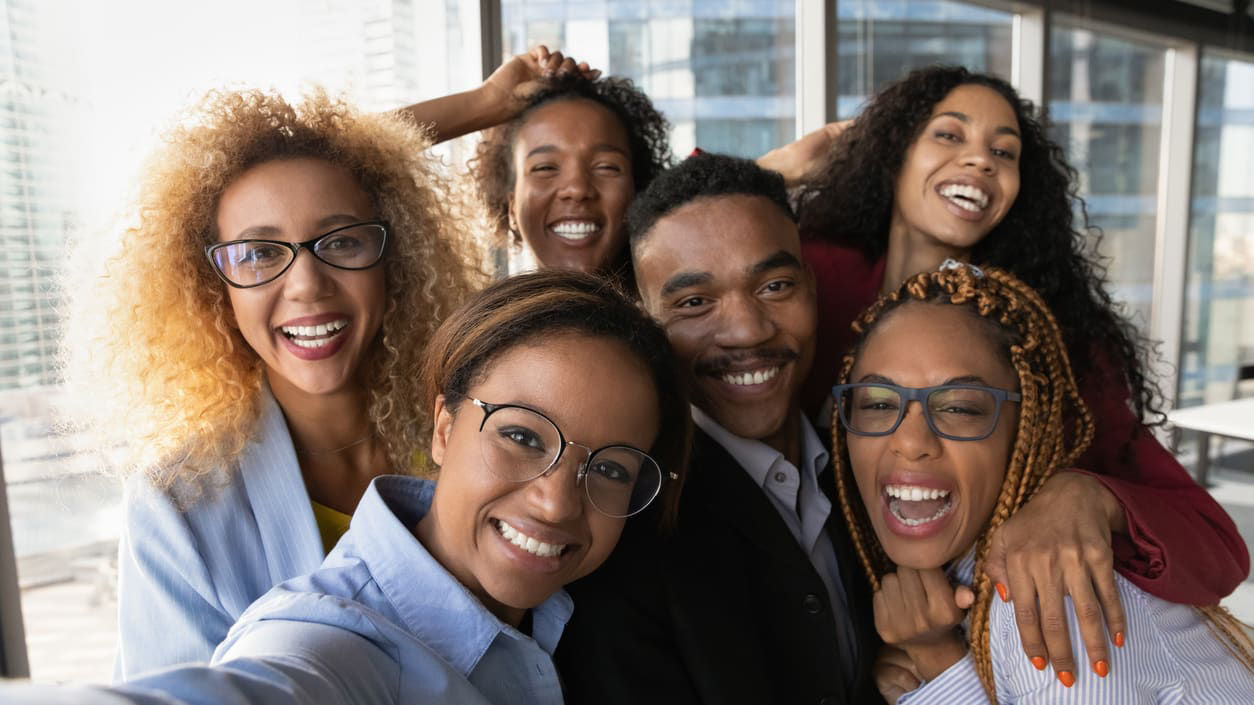 A group of business people taking a selfie in an office.