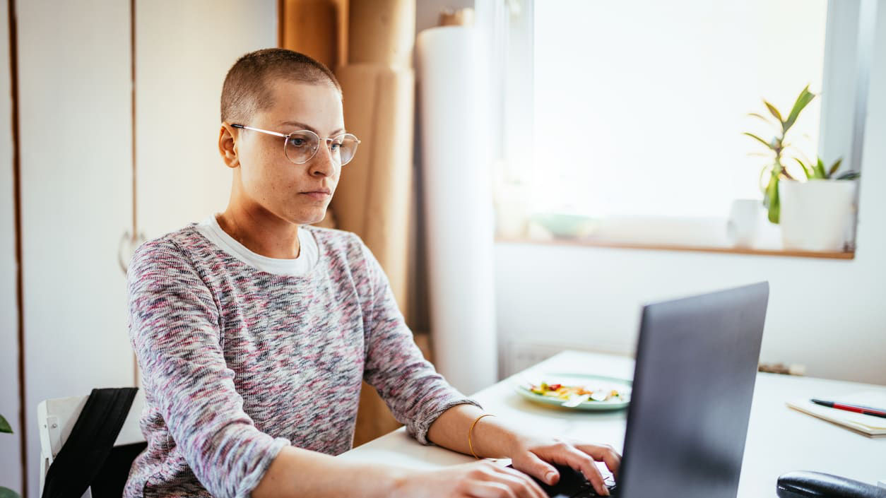 A woman working on a laptop in her home office.