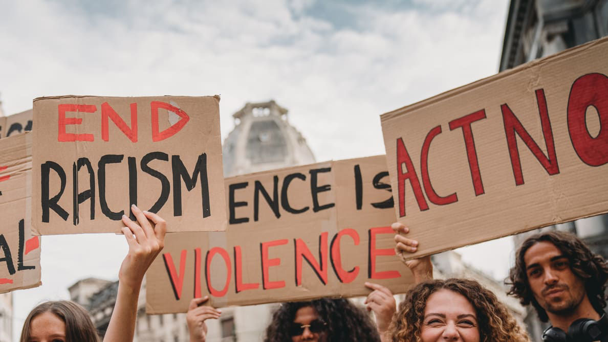 A group of people holding signs that say end racism and violence.