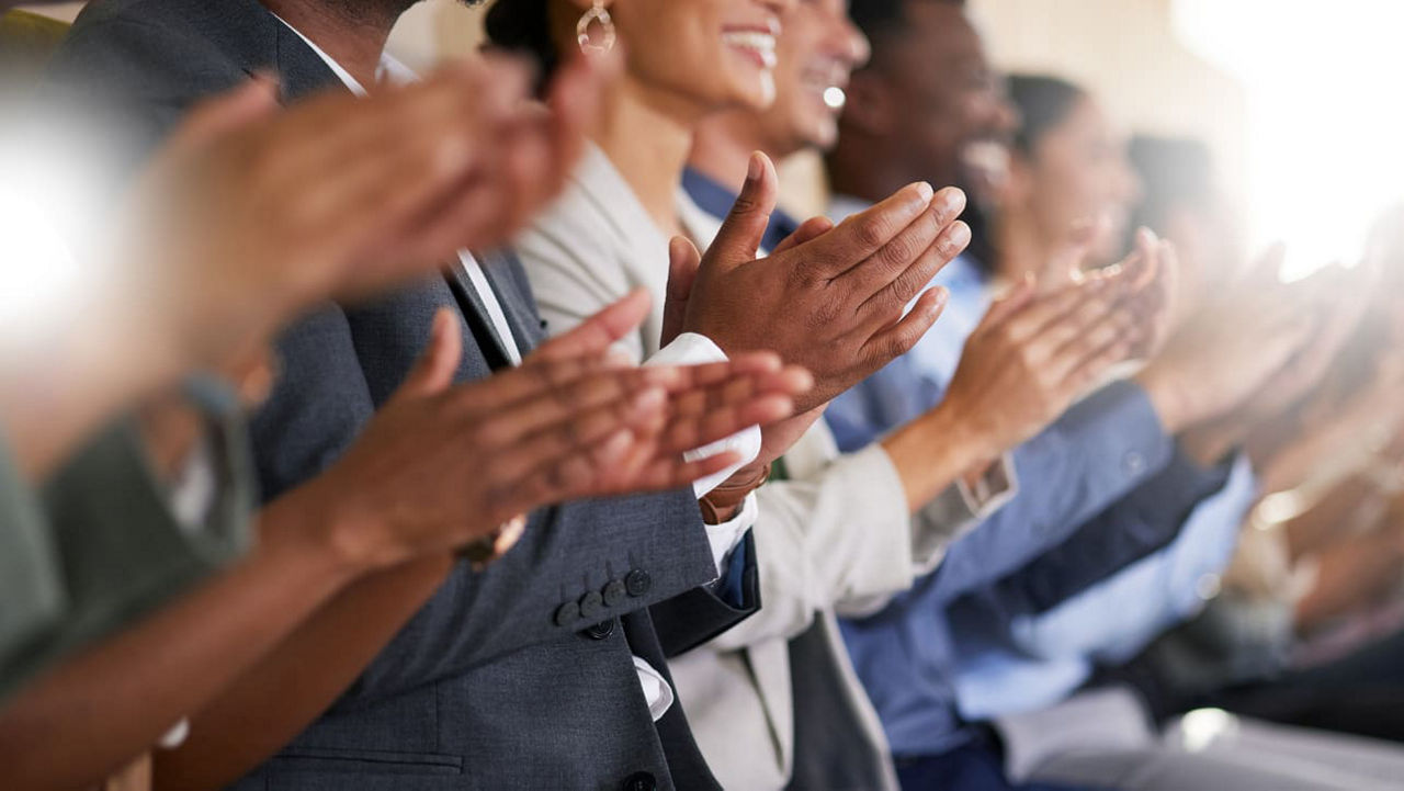 A group of people clapping their hands in a row.