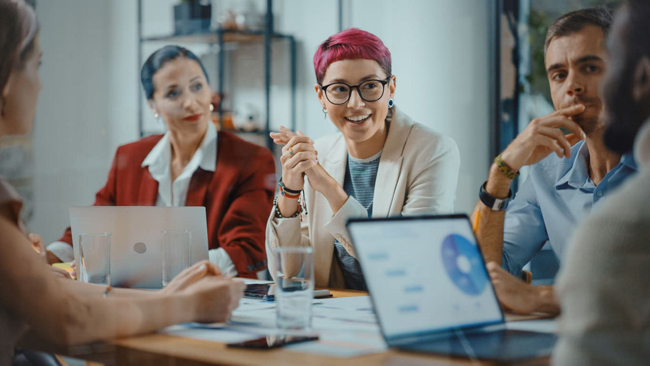 A group of people sitting around a table in a meeting.
