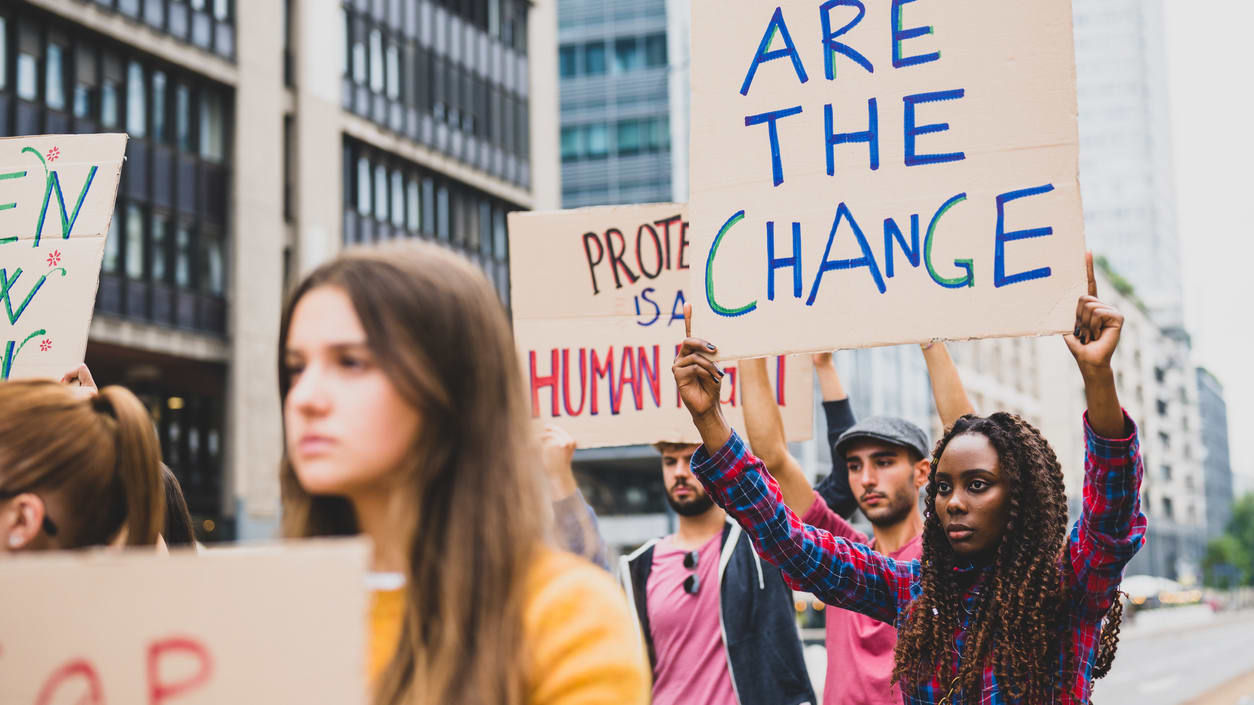 A group of people holding signs that say we are the change.