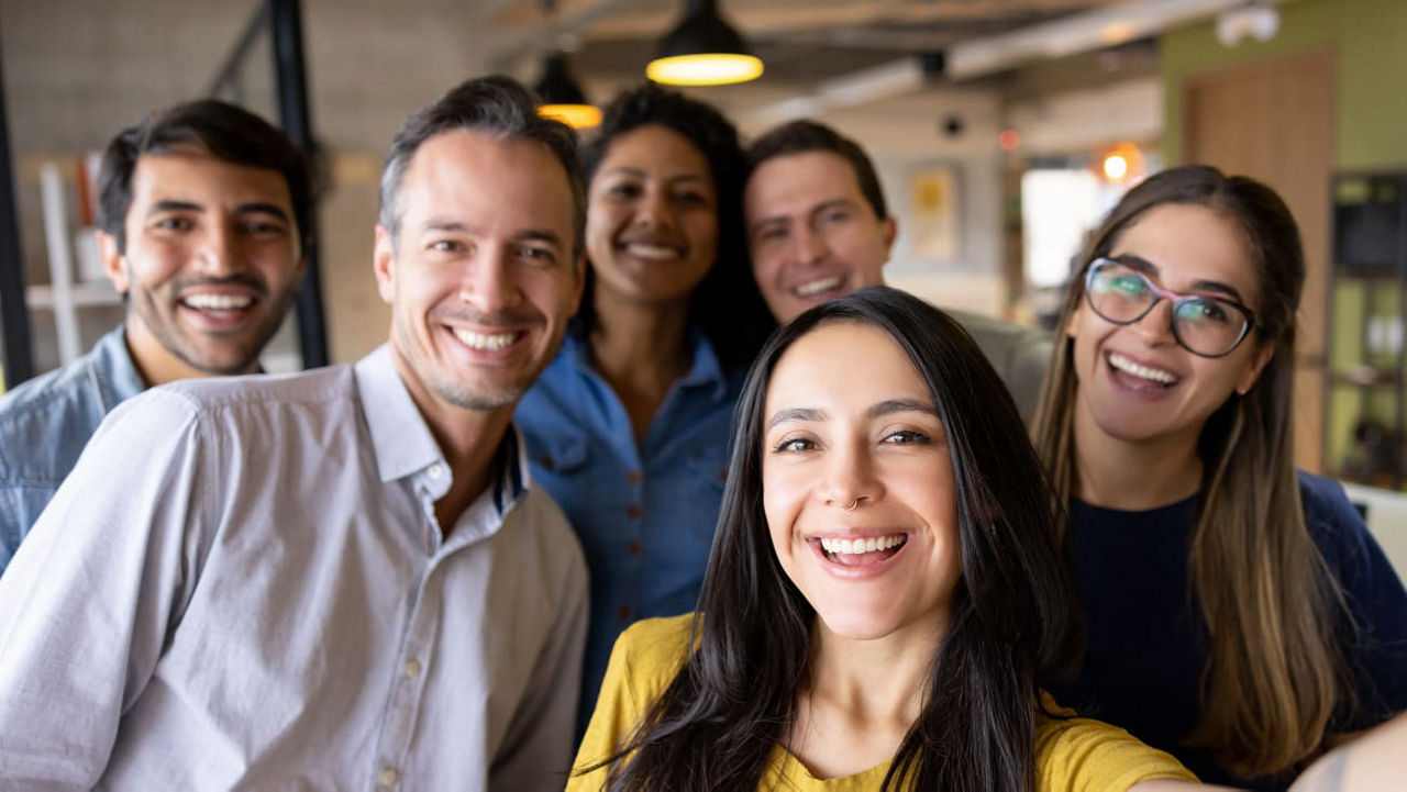 A group of people taking a selfie in an office.