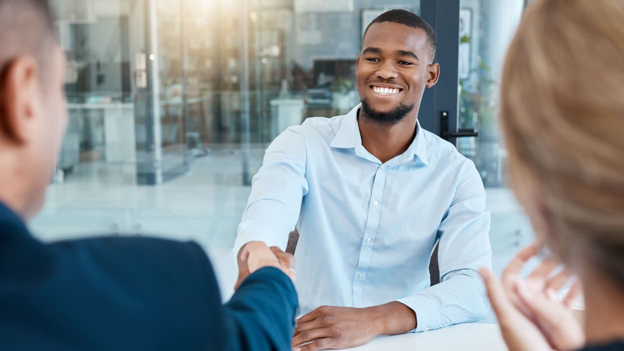 A businessman shakes hands with a woman in an office.