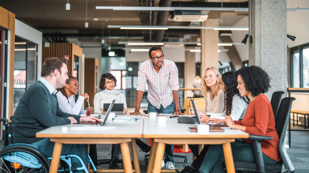 A group of people sitting around a table in an office.