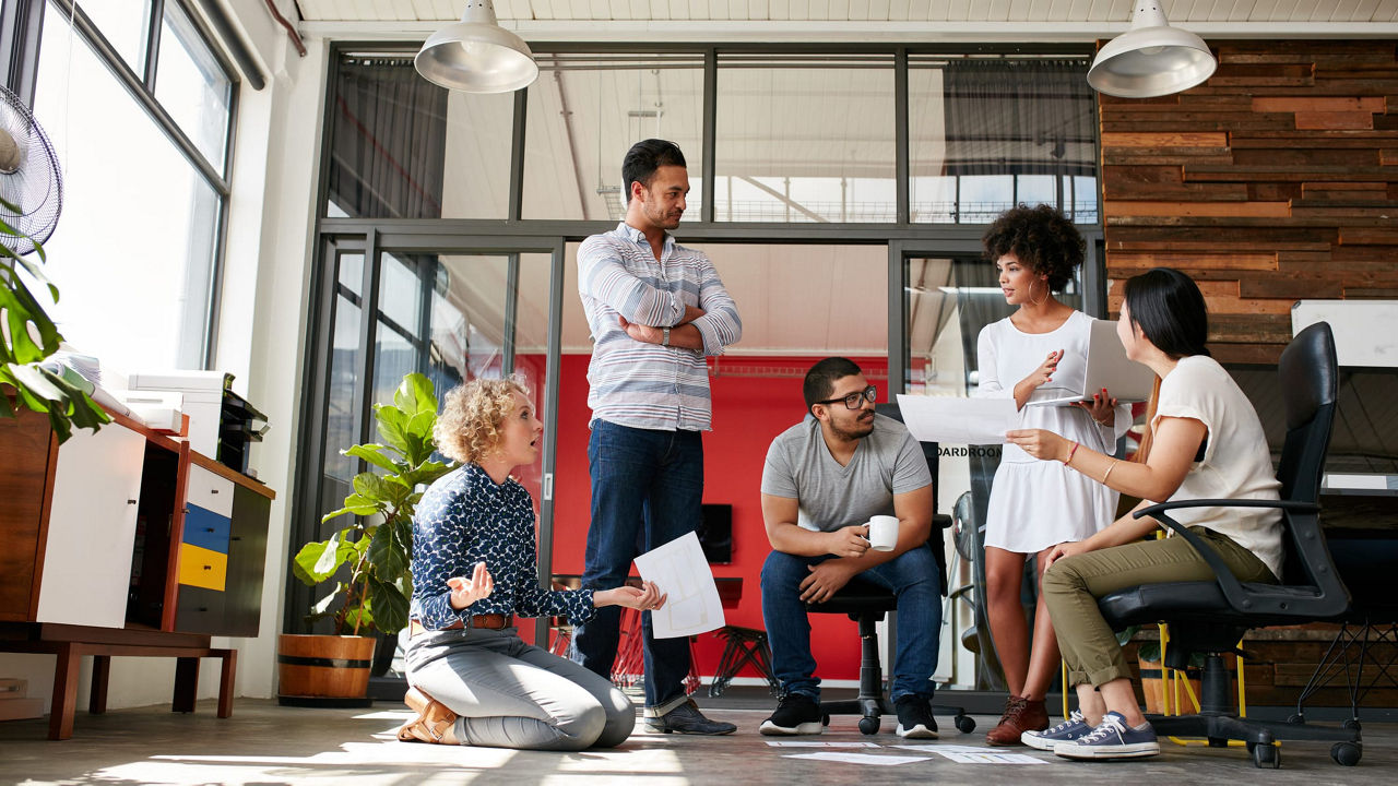 A group of people sitting around a table in an office.