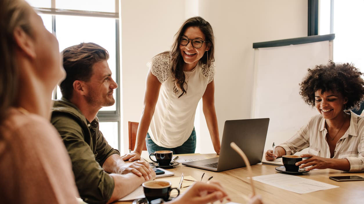A group of people sitting around a table in a meeting.