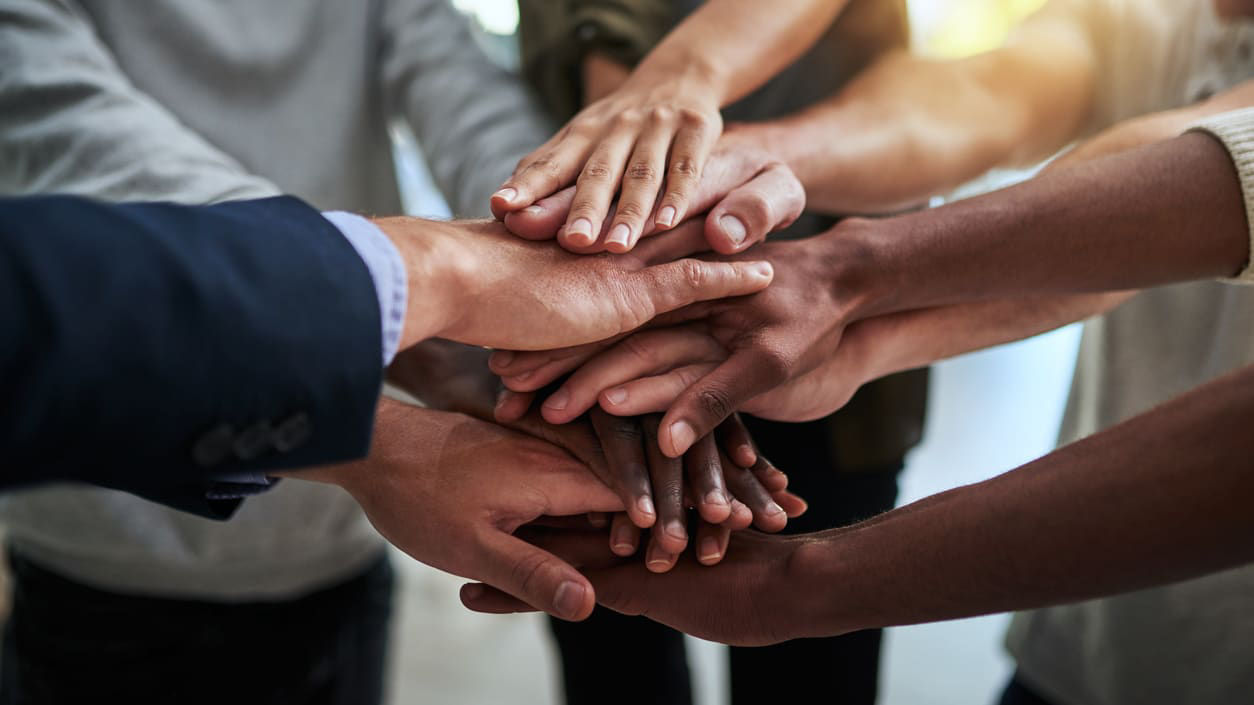A group of people putting their hands together.