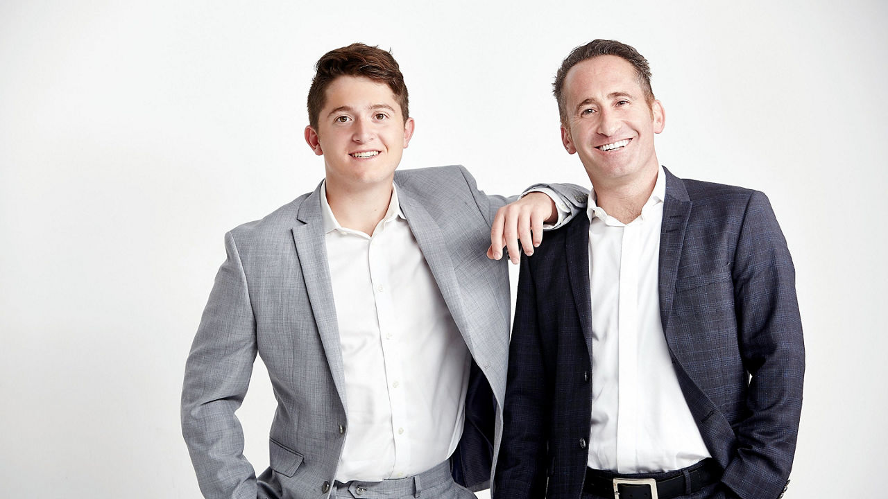 Two men in suits posing for a photo.