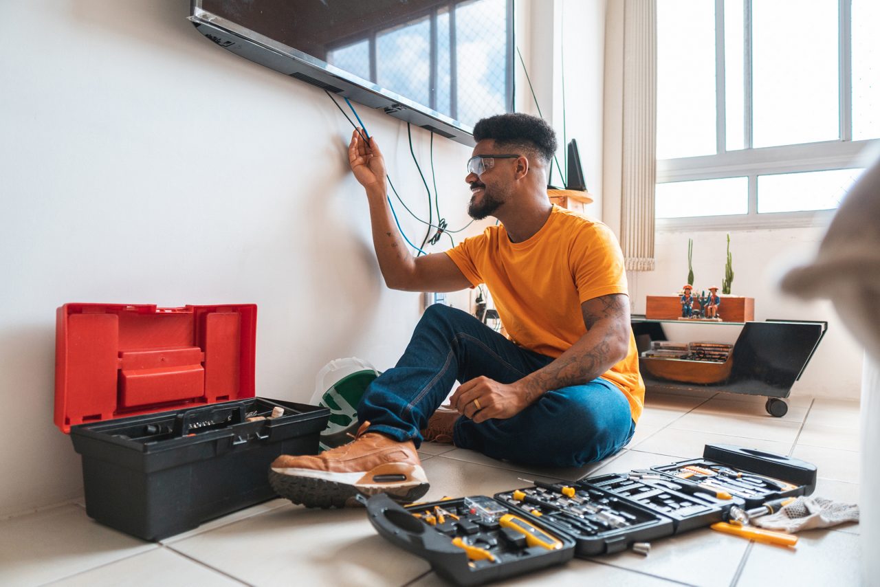 An electrician working with all two toolboxes on either side of him.