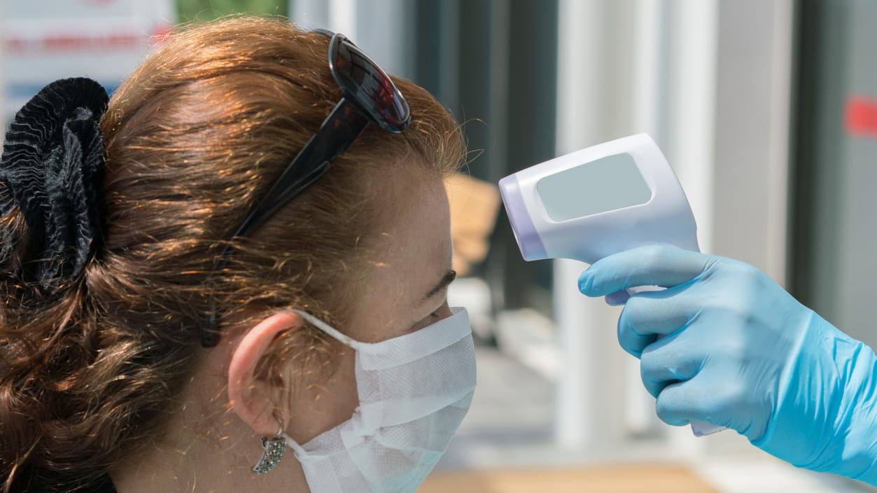 A woman wearing a mask and gloves is being tested for coronavirus.