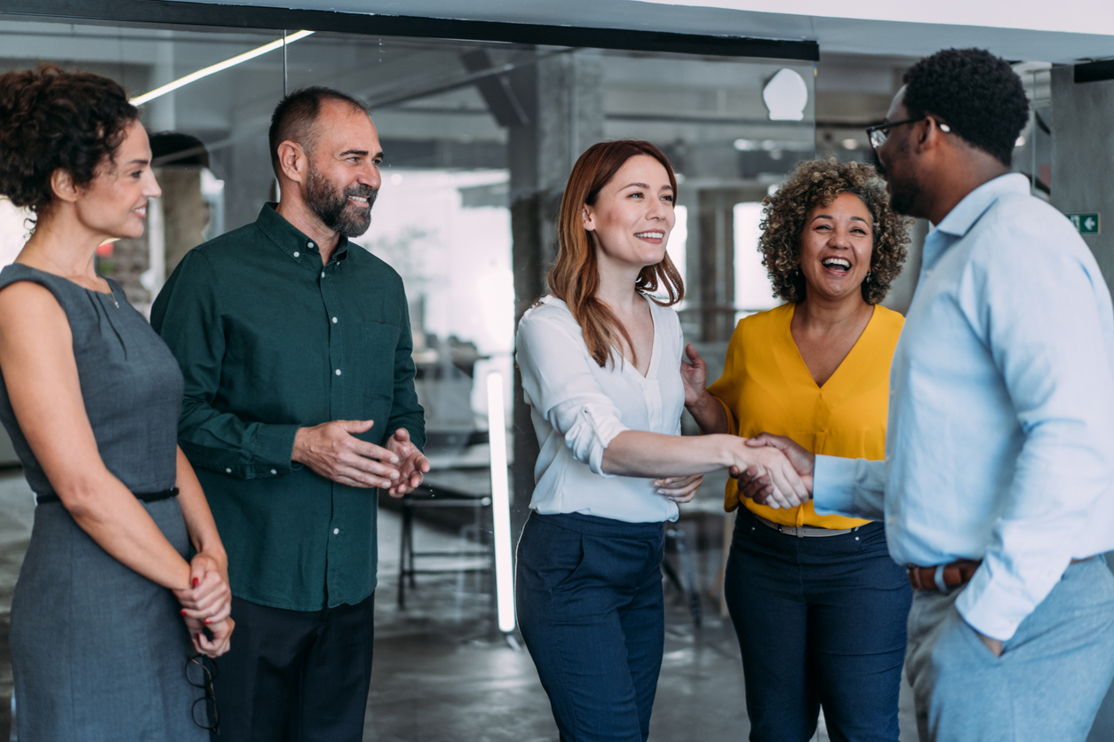 Business people shaking hands in the office. Business persons handshaking during a meeting in modern office.