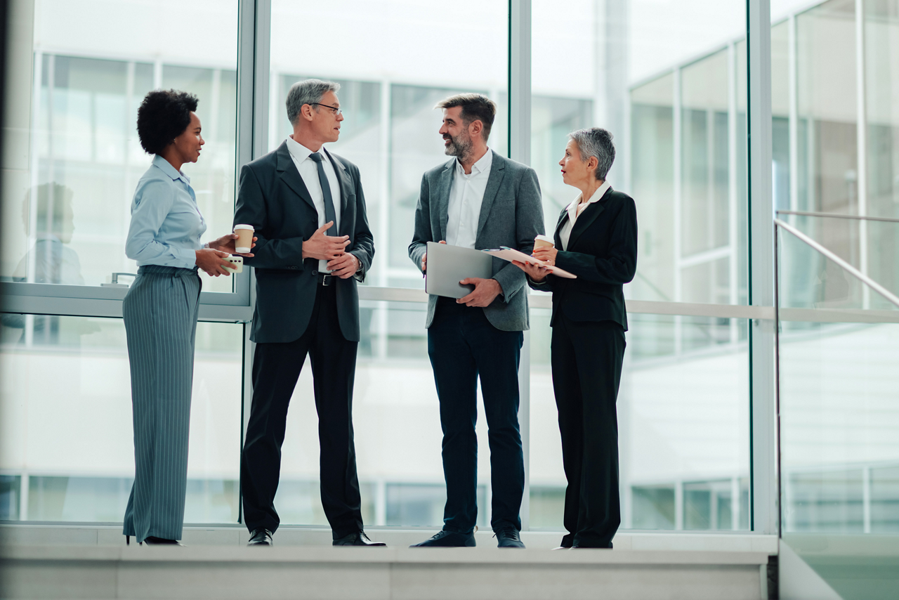 Diverse business professionals having a casual meeting, discussing strategic plans and sharing insights inside a contemporary office building