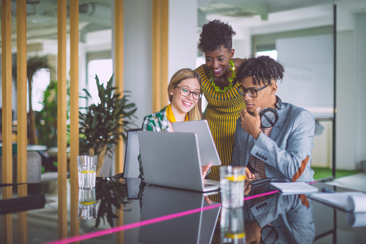Group of employees looking at laptop