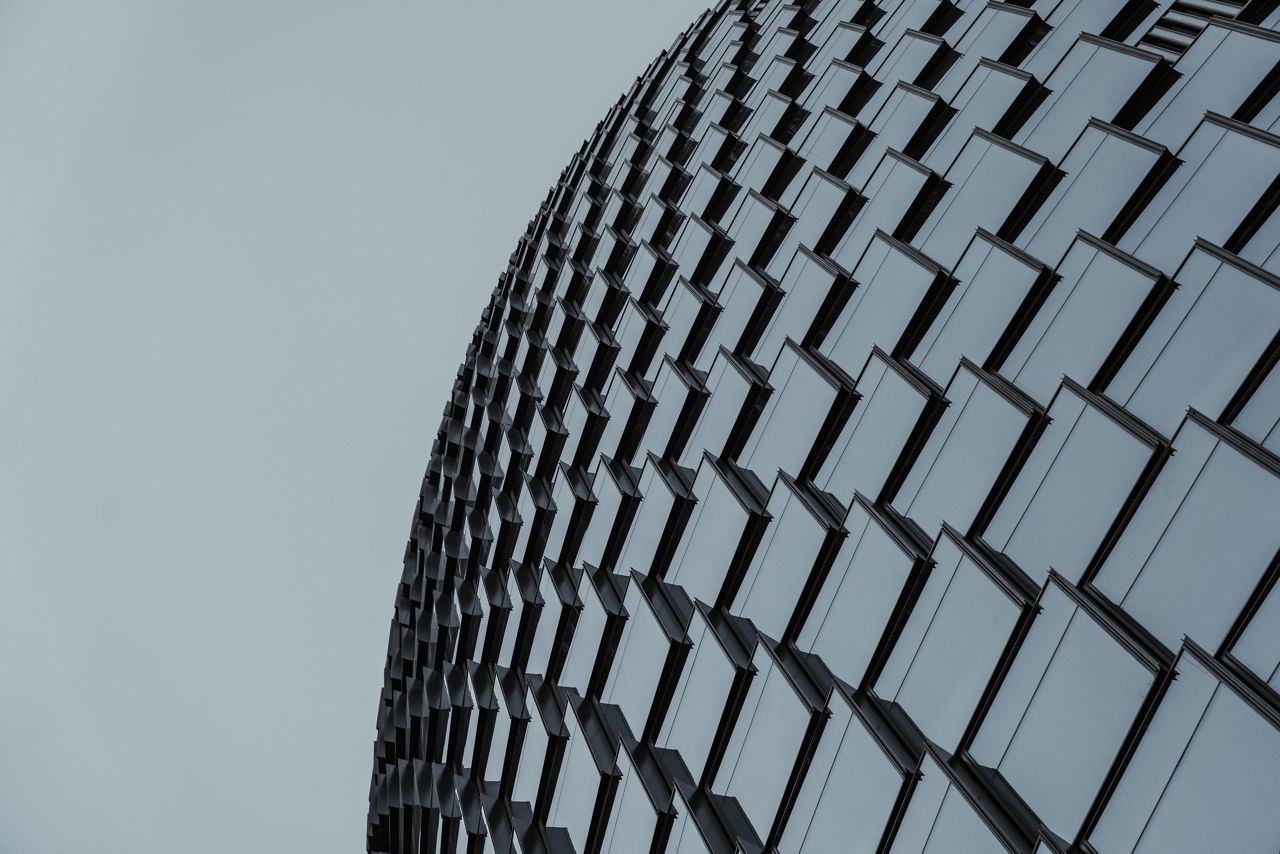 A grid of curved windows on the outside of an office building.