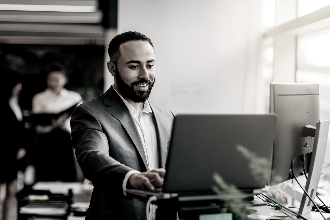 Man in a suit smiles as he works.