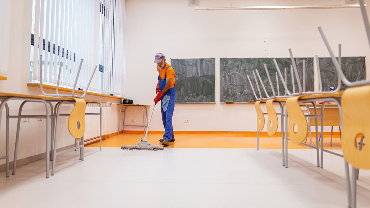 A person cleaning a classroom.