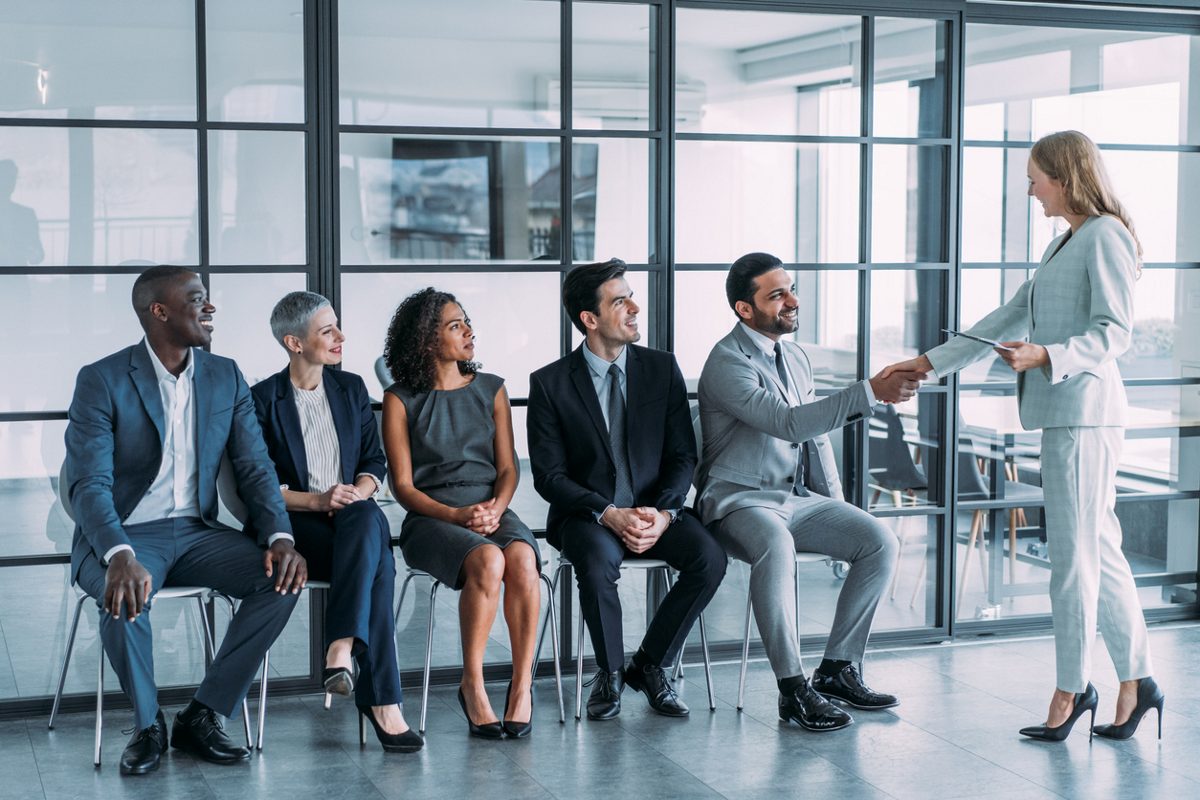 Job applicants wait outside an office.